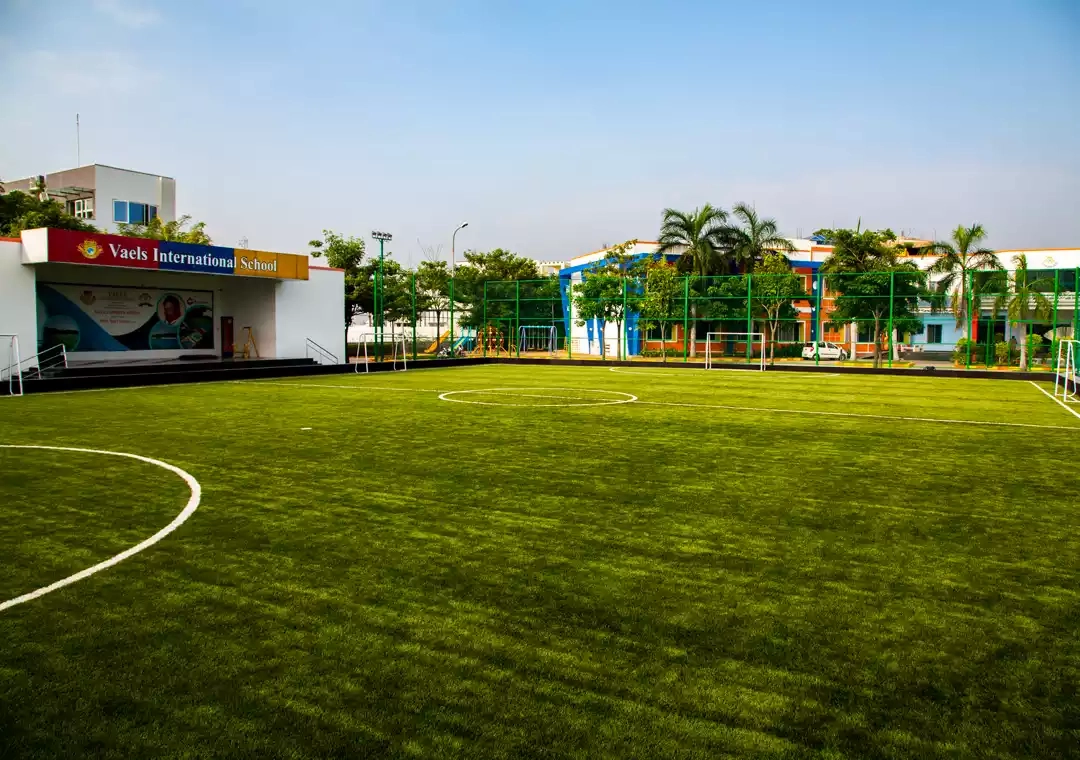 Students playing football at the Injambakkam campus sports ground