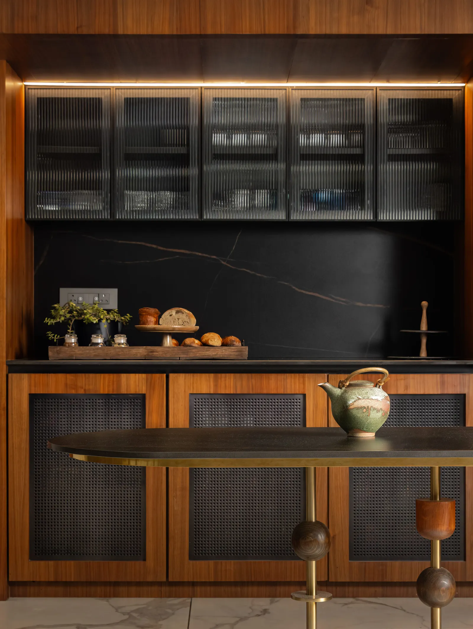 A moody pantry-bar in black marble and brass