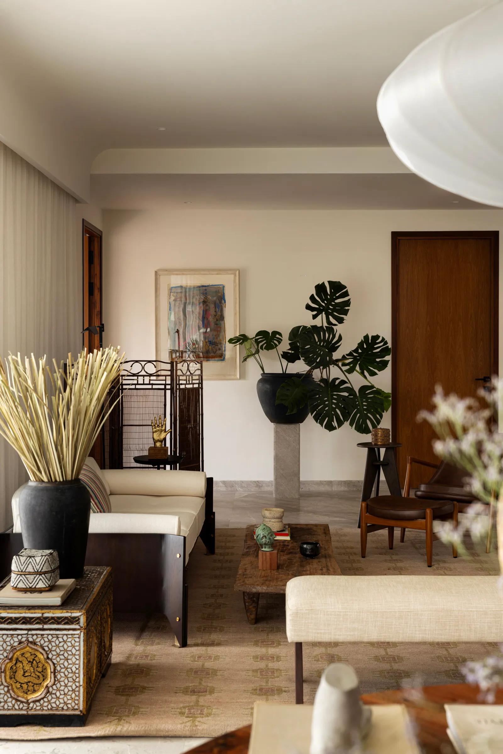 The living room, layered with art, plants and mid-century furniture