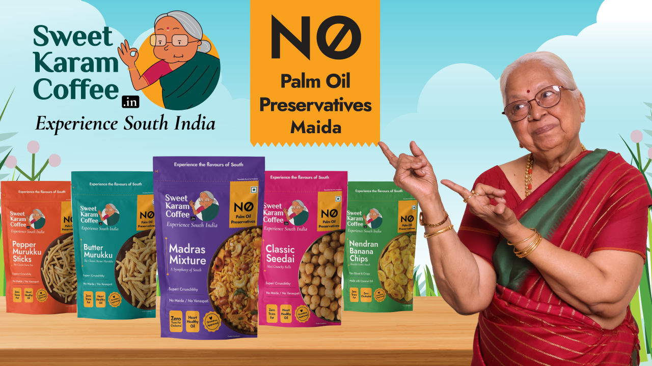 Janaki Paati surrounded by the full Sweet Karam Coffee product range including Golden Milk Mix, Filter Coffee, ABC Milk Mix and Ragi Hot Chocolate